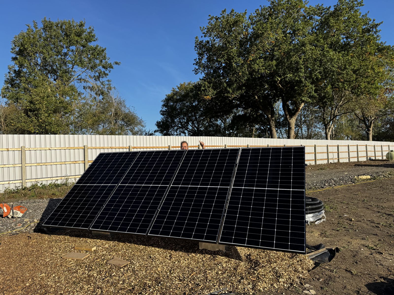 Raising a row of solar panels on a ground-mount frame
