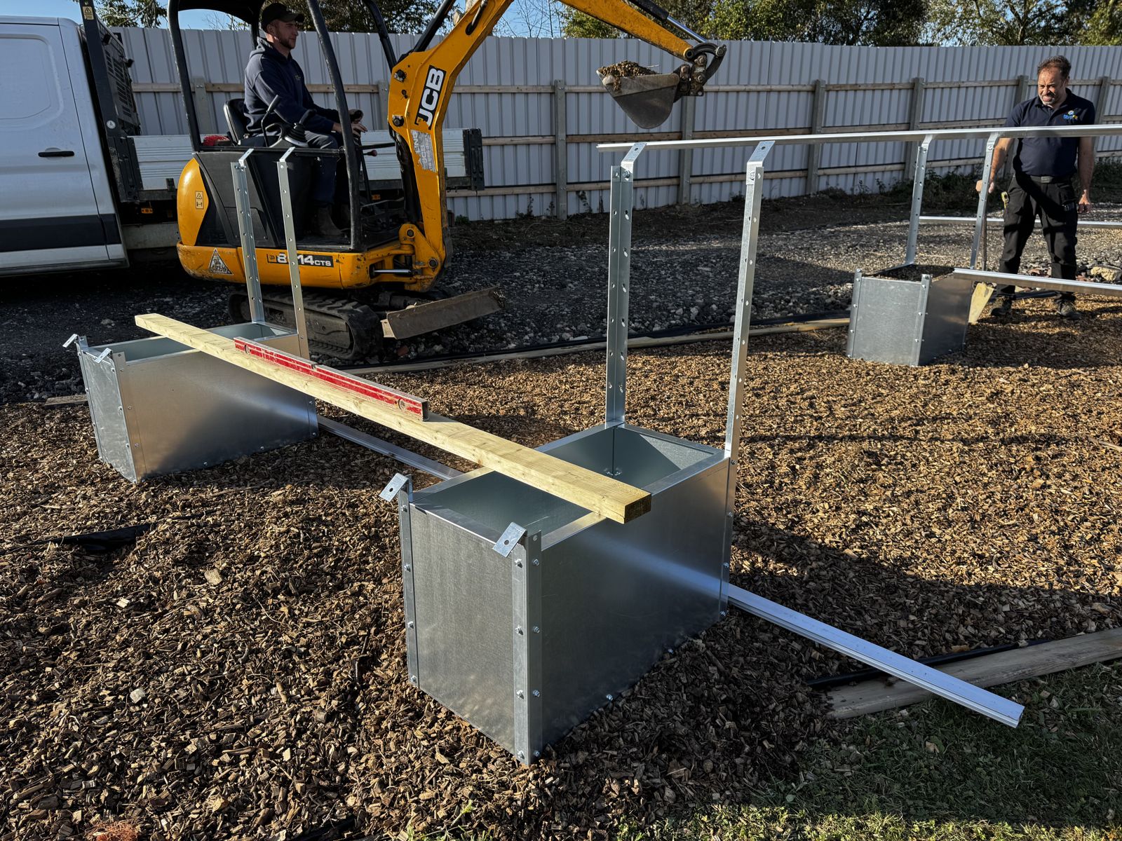 Installation team building ground-mount foundations with a mini digger